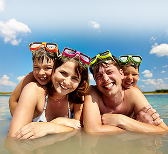 Glückliche Familie mit Taucherbrillen am Strand
