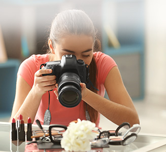 Frau hält Kamera und fotografiert Kosmetik